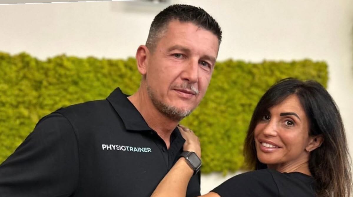 Il Dott. Bisson Federico insieme a una collega dello studio, davanti alla parete verde della reception