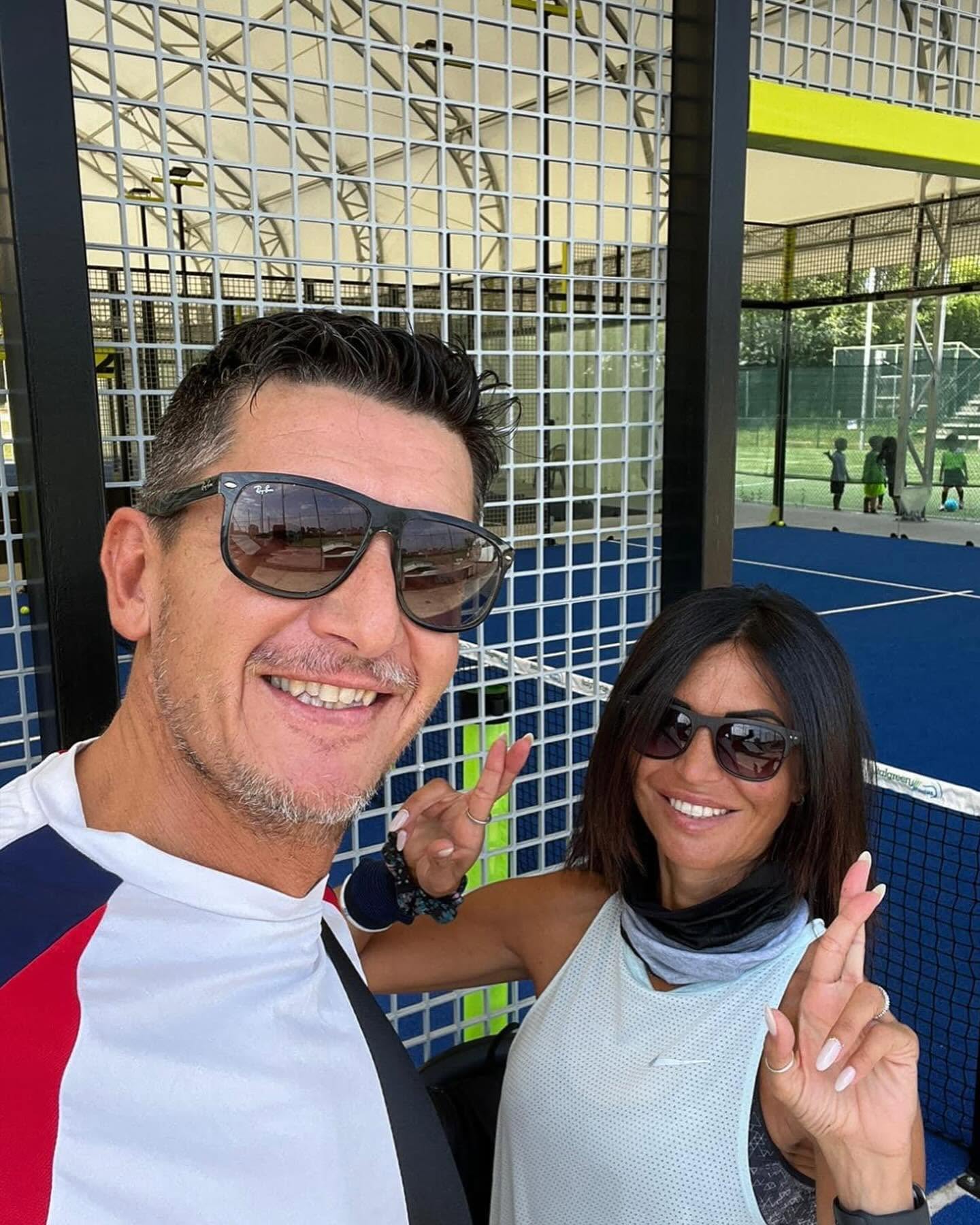 Il Dott. Bisson Federico e una collega sorridenti su un campo da padel, con gesto di vittoria